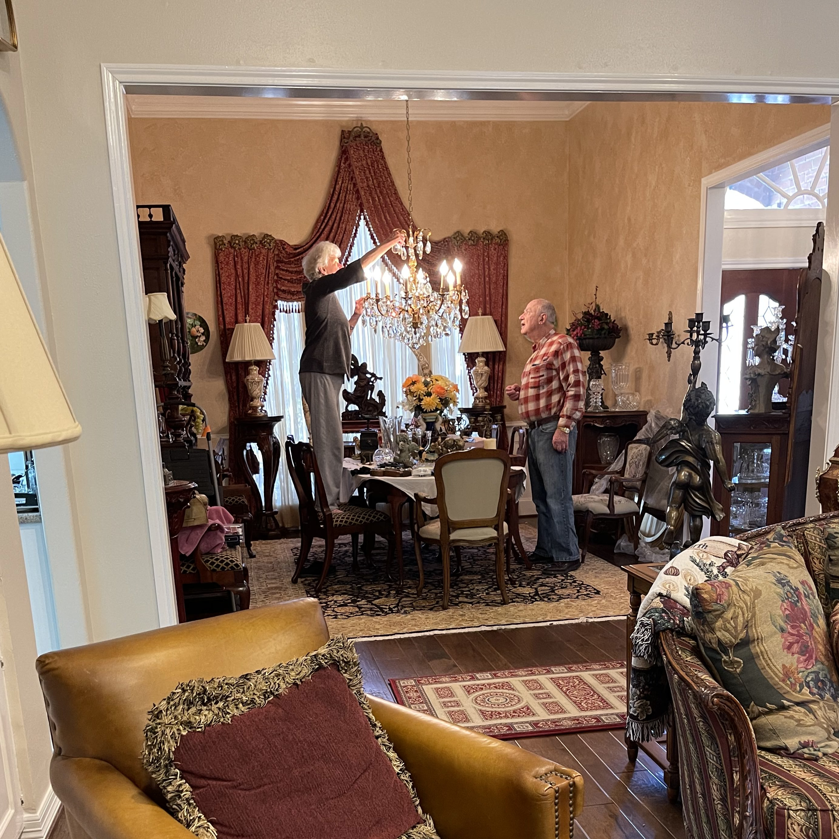 A senior couple removing a chandelier for the Summit Moving crew to crate